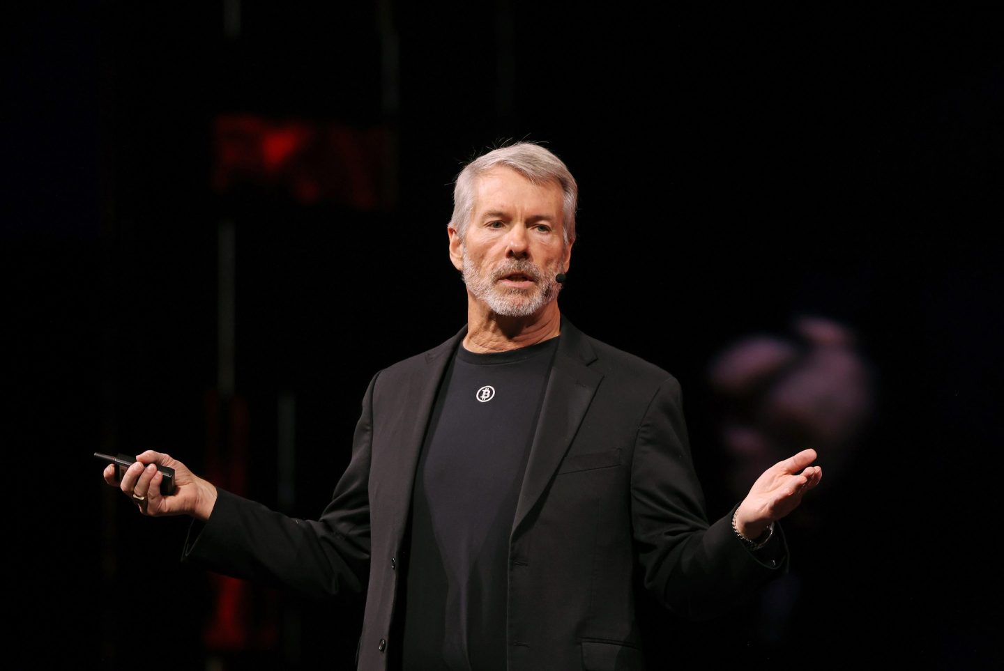 man in black blazer and black t-shirt speaks