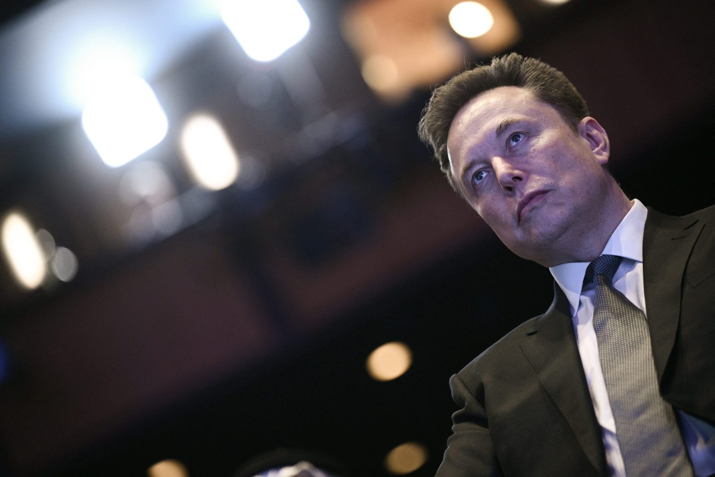 Elon Musk looks on as US President Donald Trump speaks at the US-Saudi Investment Forum at the John F. Kennedy Center for the Performing Arts in Washington, DC on November 19, 2025. (Photo by Brendan SMIALOWSKI / AFP) (Photo by BRENDAN SMIALOWSKI/AFP via Getty Images)